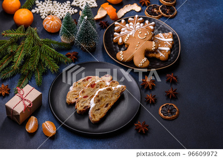 Delicious festive New Year's pie with candied fruits, marzipan and nuts on a dark concrete background Delicious festive New Year's pie with candied fruits, marzipan and nuts on a dark concrete background 96609972