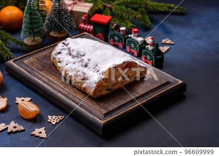 Delicious festive New Year's pie with candied fruits, marzipan and nuts on a dark concrete background 96609999