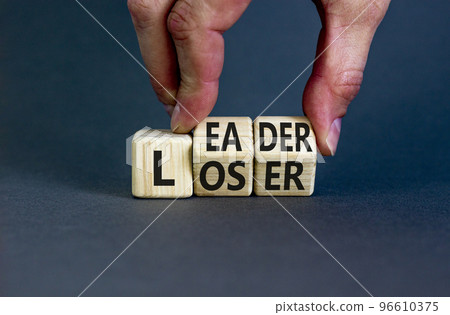 Loser or leader symbol. Concept words Loser or leader on wooden cubes. Businessman hand. Beautiful grey table grey background. Business and loser or leader concept. Copy space. 96610375