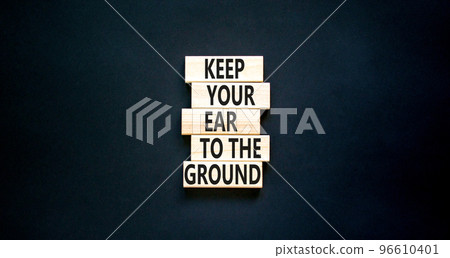 Keep your ear to the ground symbol. Concept words Keep your ear on the ground on wooden blocks. Beautiful black table black background. Business keep your ear on the ground concept. Copy space. 96610401