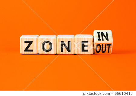 Zone in or out symbol. Concept words Zone in and Zone out on wooden cubes. Beautiful orange table orange background. Business zone in or out concept. Copy space. Zone in or out symbol. Concept words Zone in and Zone out on wooden cubes. Beautiful orange table orange background. Business zone in or out concept. Copy space. 96610413