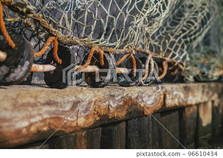 Old fishing net on a rotten wooden pier Old fishing net on a rotten wooden pier 96610434