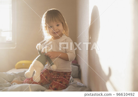 charming blonde baby with a toy in the morning 96610492