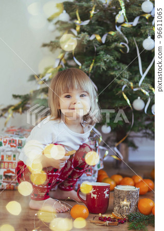 Charming child playing near the christmas tree 96611065