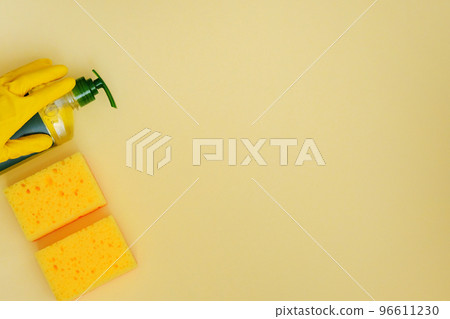 Cleaning products on yellow background. Detergent in plastic bottle and sponges. Cleaning accessories. Flat lay. Copy space. 96611230