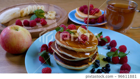 Sweet honey pouring over pancakes. Tasty breakfast food Sweet honey pouring over pancakes. Tasty breakfast food 96611881