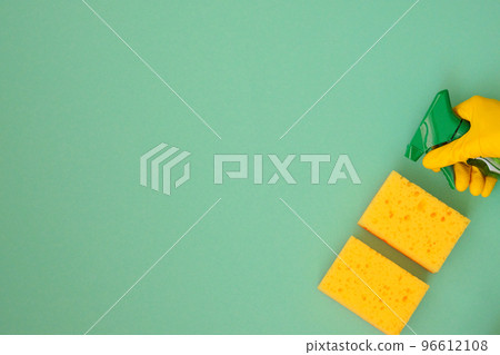 Hand in yellow rubber protective glove with sponges and detergents in spray, copy space. Service concept. Top view. Flat lay. 96612108