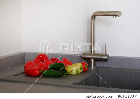 Sink with colorful vegetables in kitchen room. Modern counter with sink in kitchen room. Washing vegetables concept. 96612337