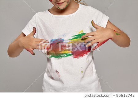 Beautiful little girl with a painted fingers is posing on a gray background. Beautiful little girl with a painted fingers is posing on a gray background. 96612742