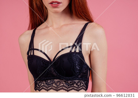 redhaired ginger woman wearing lace black underpants and bra in studio pink background 96612831