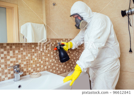 pest control worker spraying pesticides with sprayer in bathroom:processing the toilet and shower 96612841