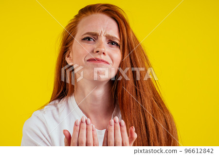ungroomed nervous unhappy young redhaired ginger woman looking at a broken fingernail and crying .nude manicure in studio yellow background.dry and split ends of hair ungroomed nervous unhappy young redhaired ginger woman looking at a broken fingernail and crying .nude manicure in studio yellow background.dry and split ends of hair 96612842