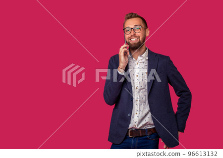 Studio shot of attractive brunette business man with glasses, in casual shirt, stylish black jacket talking on the cell phone and smiling. 96613132