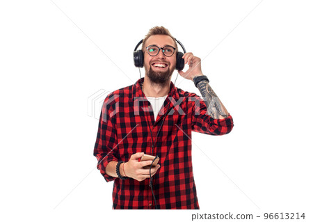 Young hipster man in checkered shirt and glasses wearing earphones looking happy on white background. 96613214