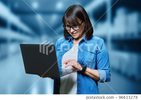 Portrait of woman manager worker using laptop in warehouse transporting 96613278