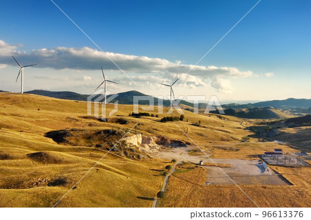 Drone view of power stations for renewable electric energy production. Windmills on sunny summer day. High wind turbines for generation electricity. 96613376
