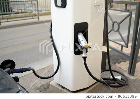 Charging modern electric car on the street of european city. Electric vehicle is an automobile of the future. Electric mobility Charging modern electric car on the street of european city. Electric vehicle is an automobile of the future. Electric mobility 96613389