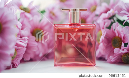 A perfume bottle surrounded by pink chrysanthemum flowers. Eau de toilette, eau de parfum, beauty concept A perfume bottle surrounded by pink chrysanthemum flowers. Eau de toilette, eau de parfum, beauty concept 96613461