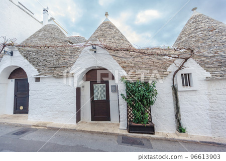 Beautiful town of Alberobello with Trulli houses among green plants and flowers, Apulia region, Southern Italy. Beautiful town of Alberobello with Trulli houses among green plants and flowers, Apulia region, Southern Italy. 96613903