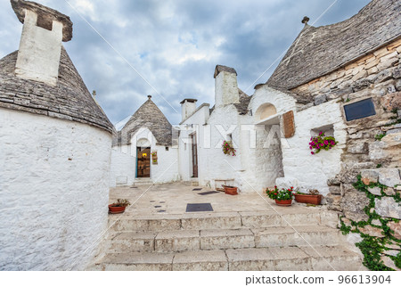 Beautiful town of Alberobello with Trulli houses among green plants and flowers, Apulia region, Southern Italy. Beautiful town of Alberobello with Trulli houses among green plants and flowers, Apulia region, Southern Italy. 96613904