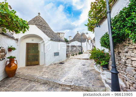 Beautiful town of Alberobello with Trulli houses among green plants and flowers, Apulia region, Southern Italy. Beautiful town of Alberobello with Trulli houses among green plants and flowers, Apulia region, Southern Italy. 96613905