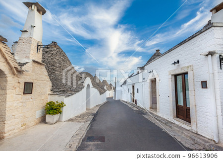 Beautiful town of Alberobello with Trulli houses among green plants and flowers, Apulia region, Southern Italy. 96613906