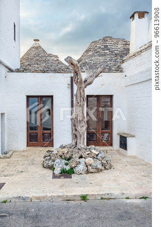 Beautiful town of Alberobello with Trulli houses among green plants and flowers, Apulia region, Southern Italy. Beautiful town of Alberobello with Trulli houses among green plants and flowers, Apulia region, Southern Italy. 96613908