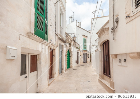 View of the old town of Martina Franca with a beautiful houses painted in white. View of the old town of Martina Franca with a beautiful houses painted in white. 96613933