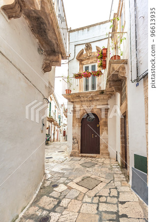 View of the old town of Martina Franca with a beautiful houses painted in white. View of the old town of Martina Franca with a beautiful houses painted in white. 96613935