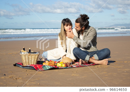 Romantic Caucasian couple enjoying picnic at seashore Romantic Caucasian couple enjoying picnic at seashore 96614650