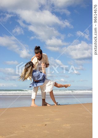 Loving Caucasian couple dancing at the beach 96614676