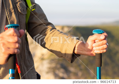 Close-up of hand with blue walking poles Close-up of hand with blue walking poles 96614713