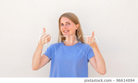 Cheerful young woman showing thumbs up Cheerful young woman showing thumbs up 96614894
