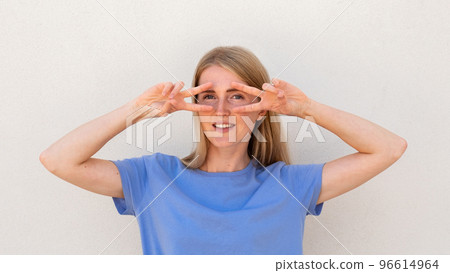 Cheerful young woman showing V-signs near her eyes 96614964