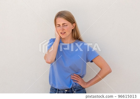 Dissatisfied young woman holding hand on her ear 96615013