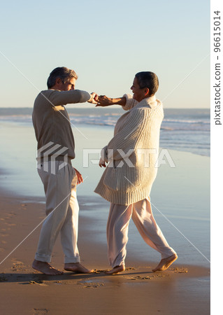 Romantic senior couple spending time at seashore at sunset 96615014