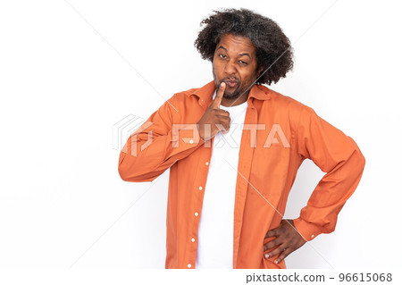 Portrait of mid adult man touching lip and squinting eyes 96615068