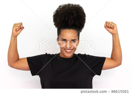Portrait of happy young woman showing biceps 96615081