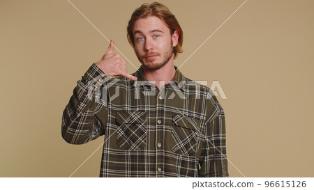 Cheerful one man in shirt looking at camera doing phone gesture like says hey you call me back Cheerful one man in shirt looking at camera doing phone gesture like says hey you call me back 96615126