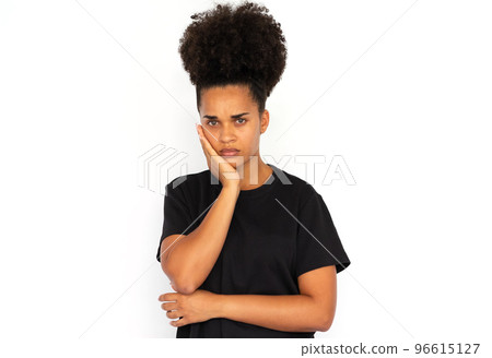 Portrait of bored young woman leaning head on hand Portrait of bored young woman leaning head on hand 96615127