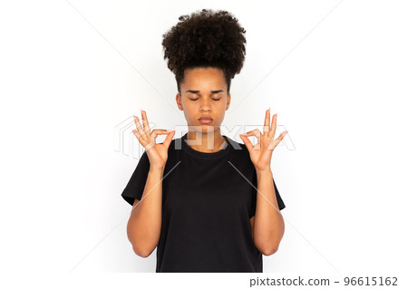 Portrait of concentrated young woman meditating 96615162