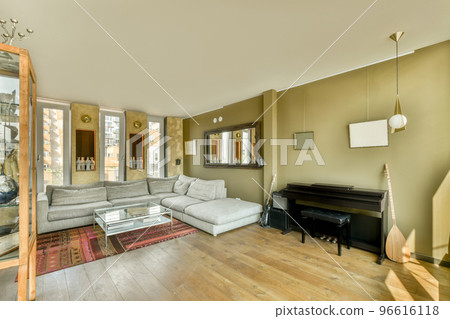Table with chairs and comfortable sofa located in in spacious room with stylish decorations in modern apartment 96616118