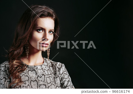 Portrait of stylish young woman with beautiful hair and luxury earrings wears in dress snake print Portrait of stylish young woman with beautiful hair and luxury earrings wears in dress snake print 96616174