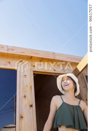 Young woman exiting outdoor sauna at campsite Cabin style sauna Finnish outdoor sauna 96617057