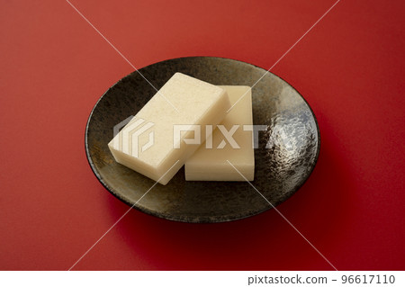 Mochi on red background. Cut rice cakes, square rice cakes. Mochi on red background. Cut rice cakes, square rice cakes. 96617110