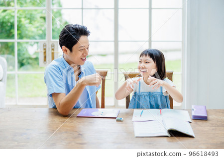 Dad teaching daughter to study at home 96618493