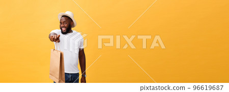 African American man with colorful paper bags isolated on yellow background African American man with colorful paper bags isolated on yellow background 96619687