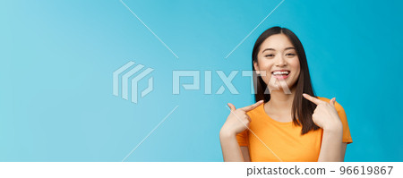 Close-up proud boastful cute asian girl telling story pointing herself, smiling broadly, bragging new haircut, standing pleased, delighted tell big news, stand blue background upbeat 96619867