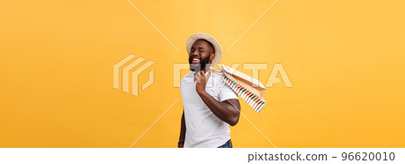 Happy african american man holding shopping bags on yellow background. Holidays concept Happy african american man holding shopping bags on yellow background. Holidays concept 96620010