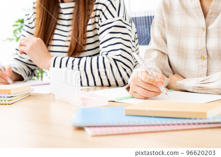 Hands of two female college students studying Hands of two female college students studying 96620203